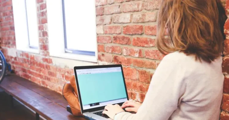 Person typing SEO title tags and meta descriptions on a laptop