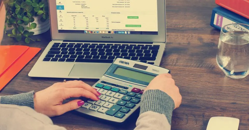 Business owner calculating website budget on a laptop